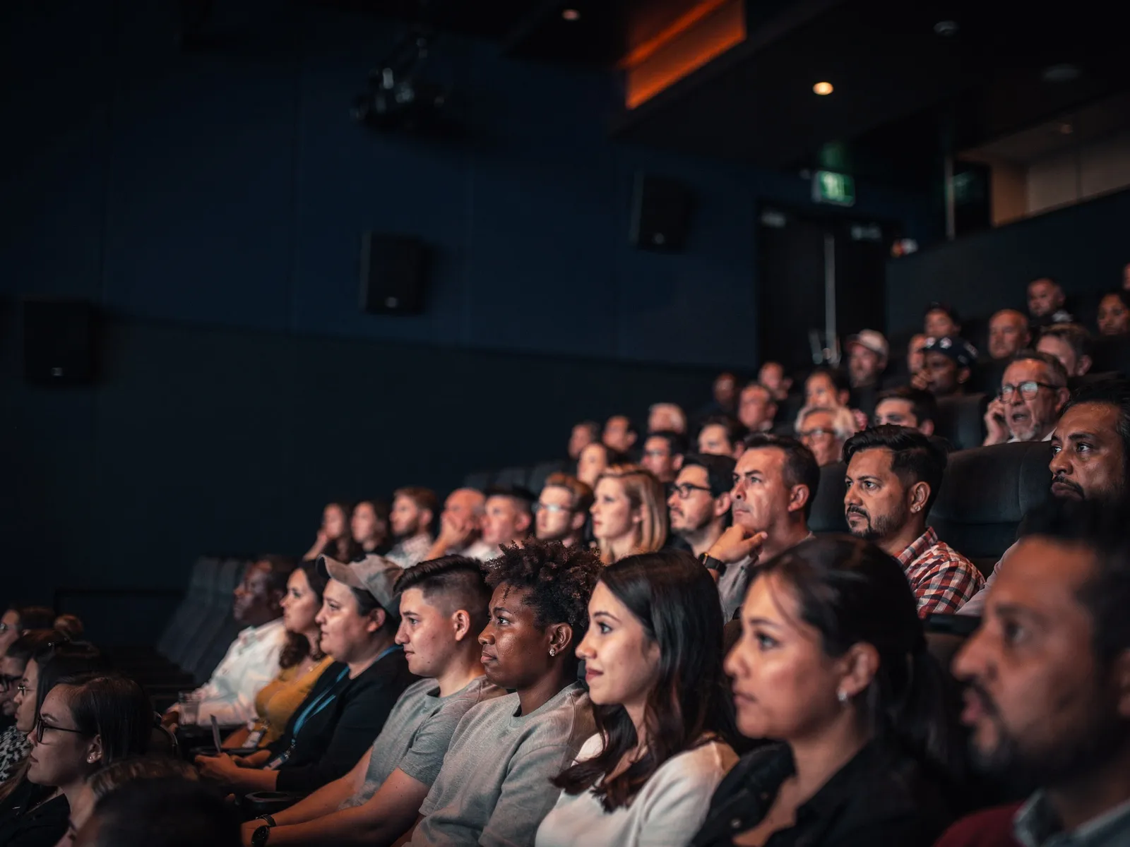 An audience in low warm light, watching